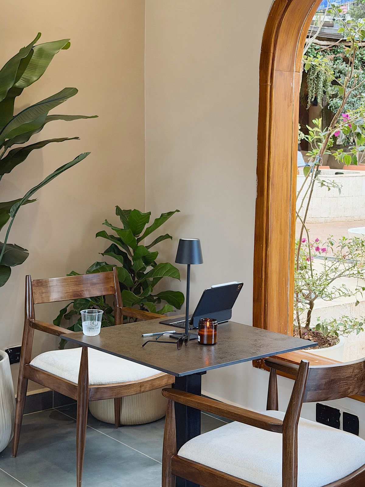 A corner table beside an arched window at Chloe Café
