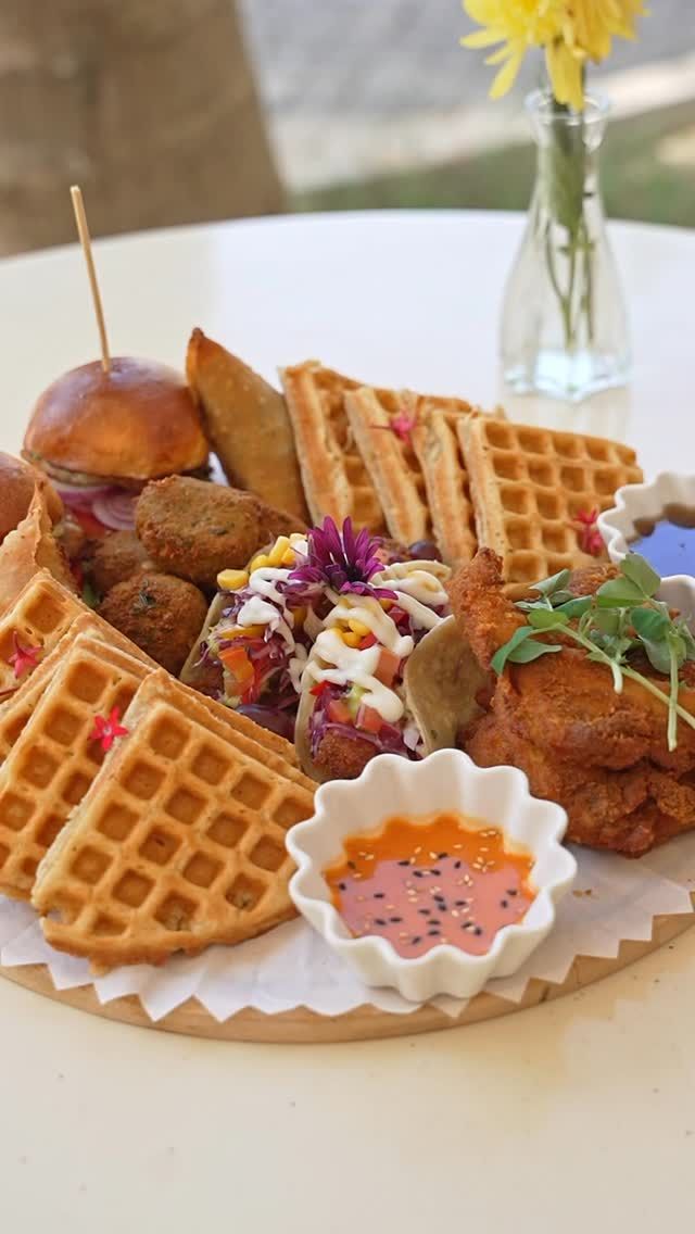 Waffles, sliders, tacos and fried chicken on a wooden board